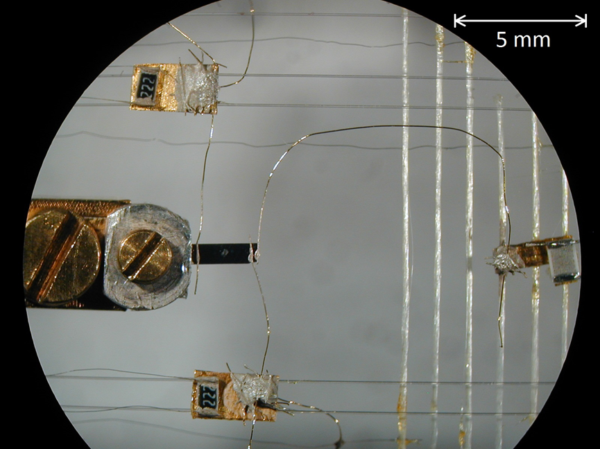 Figure 3: The setup used for thermal conductivity measurements in which high resolution thermometers and a heat source are thermally anchored to a single crystal sample. One end of the sample is tightly coupled to an external heat bath, from which the thermometers and heater are simultaneously decoupled.