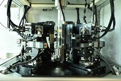 Advanced industrial machinery setup with interconnected cables, mechanical components, and precision instruments in a compact area.